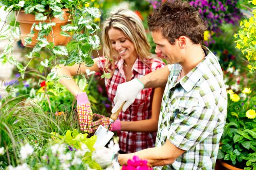 Workers managing garden waste and rubbish removal in a controlled outdoor setting